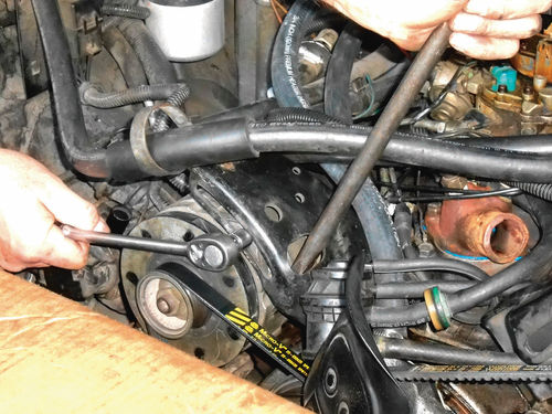 Photo 64. A pry bar can be carefully used against the forward alternator casting for tightening the belt.
