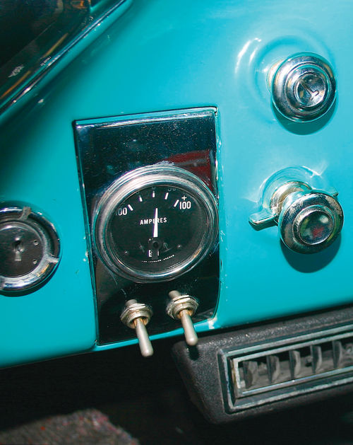 A 100-amp capacity ammeter is mounted where the ashtray used to be. The toggle switches operate an auxiliary fan and an electric fuel pump for priming the carburetors. You can also just go with a voltmeter.