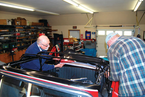 Ken Nimmocks (left) gave Bob Hansen a few lessons about installing a convertible top. Careful measuring from the center is an important part of this job.