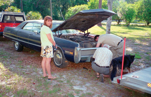 Though in a hurry to load up and go, Carolyn (pictured) and I allowed the seller and his neighbor to remove a local-interest license plate from the Imperial.