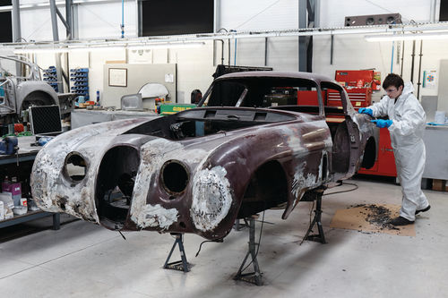 A technician smoothes the Jaguar’s body at the CMC shop.