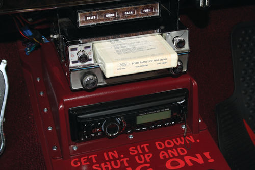 An aftermarket, period-correct 8-track stereo (with a Ford-issued 8-track tape) is suspended from the dash and a modern CD player is mounted in a console custom-built by the owner. The optional “Convenience Group” is visible above the stereo equipment.