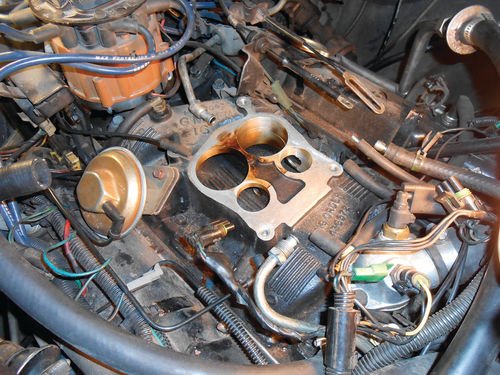 That staining on the manifold mounting surface was caused by internal carburetor fuel leakage.