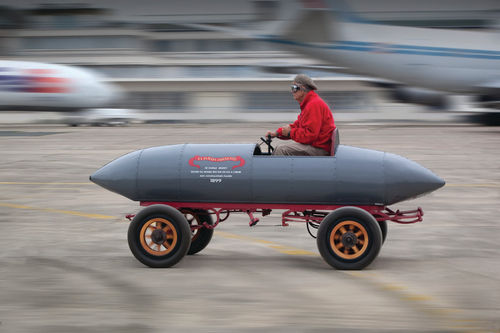 Nattily attired in a flat cap, goggles and red jacket, contributor Sherman goes for a drive.