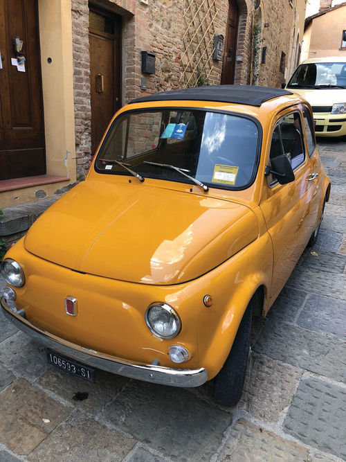 A bright yellow Fiat 500 spotted on the street in Rome. Fiats are very common in Italy, but this one is well-maintained and almost void of scratches, making it a rather unique find!