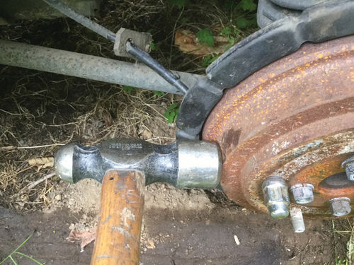 After other methods failed to free the frozen brake, I resorted to my large ball-peen hammer. Hitting the brake drum directly over the shoes with a few careful whacks was enough to allow the brake drum to rotate.