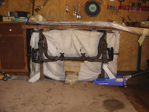 The front suspension was mounted under a workbench to allow spring removal.