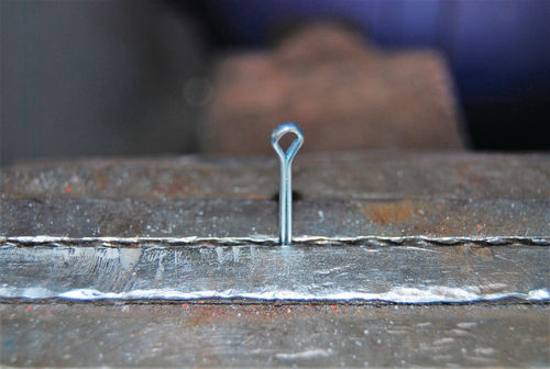 For a safer fit, clamp half of the cotter pin in a vise like this.