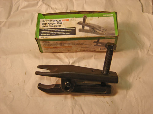 An inexpensive ball joint separator provided the key to removing the retaining bolt.