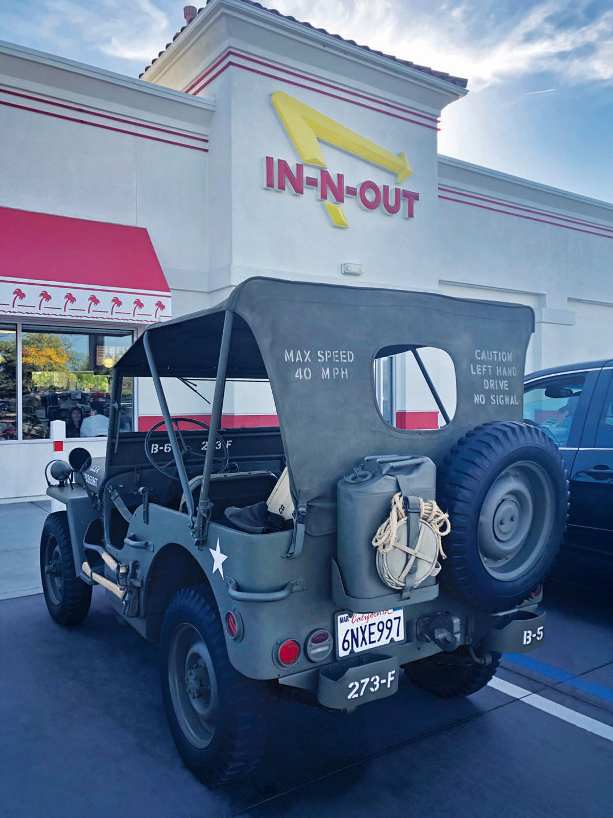 A Willys Jeep parked outside In-N-Out Burger in Long Beach, California. Note the rope and extra gas tank on the back.