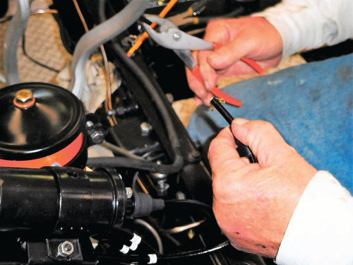 Larry puts a flap-type clip on a coil wire that attaches to the distributor cap center tower.