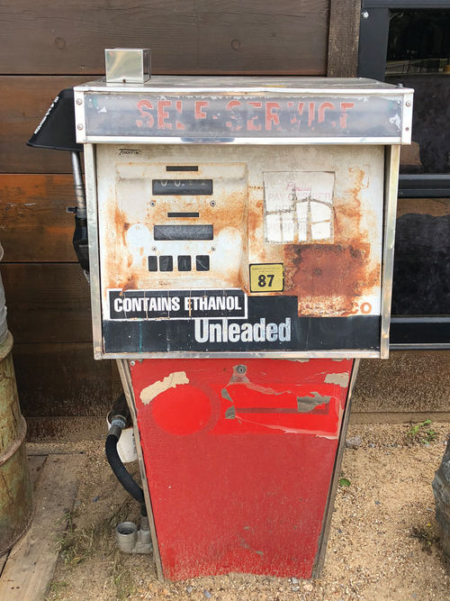 An original “unleaded” gas pump outside of the restaurant with a small yellow sign reading: “minimum octane rating 87.” How different it was to pump your gas from one of these.