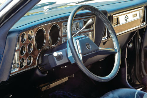 Paint, brightwork and the Chrysler name combine to make an unusual side-mirror. Full instrumentation, woodgrain and brightwork make for an attractive dashboard.