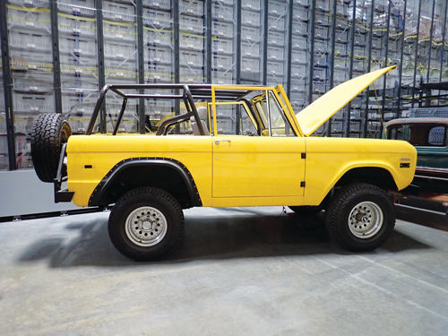 A bright yellow Bronco in the warehouse, undoubtedly awaiting its turn for some hand assembled parts.