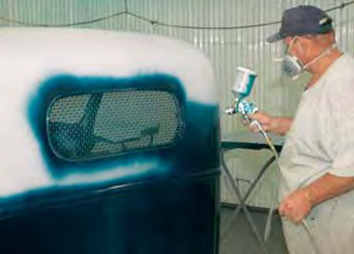 Spraying dark blue paint onto truck