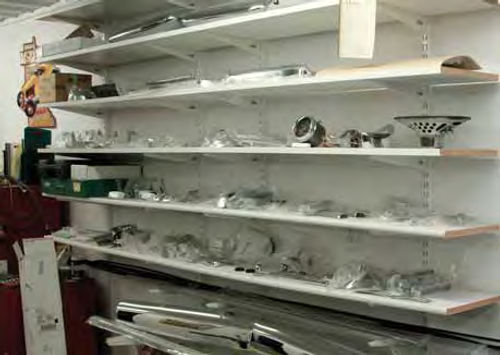 Kopecky keeps all similar parts grouped together. The shelves and wall brackets in this area of his shop hold all the bright work for one car.