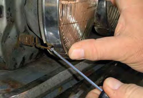 Photo 2. Releasing the headlight retaining spring used on many vehicles.