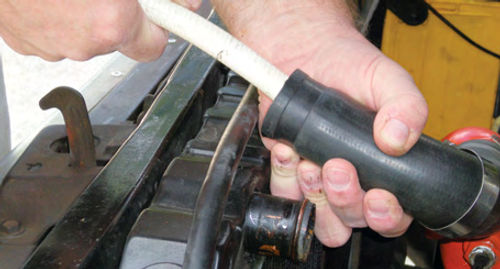 Photo 19. A final “reverse direction” rinsing of the block through the upper radiator hose.