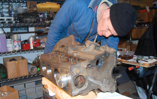 MG T pistons and rods need to be installed from the bottom and pushed through for ring installation. Vince laid the block on its side to make the job easier.