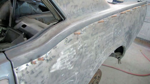 Photo 17. Blind holders are used to secure the new quarter panel to the car for welding.