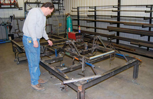 Rich Bickle uses a chassis jig on a bolt-in frame at the Muscle Up Performance and Rod Shop.