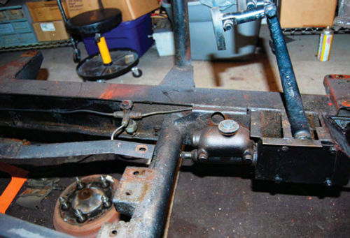 The TD’s brake master cylinder mounts to the frame behind the pedal box.