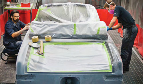 Technicians mask off a vehicle in the Center’s paint booth.