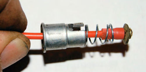 A small tension spring and bulb holder were pulled up over the pigtail wire and positioned so the spring and fiber washer could be pulled into the bulb holder.