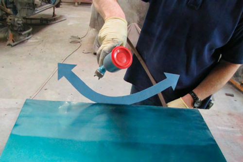 Photo 3. The paint gun is swung in an arcing motion over the repair area in order to blend the colors.