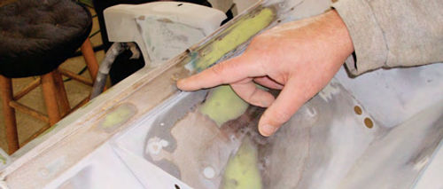 John Diermeier points to spots on the car’s firewall where a skim coat of plastic filler was used for final smoothing.