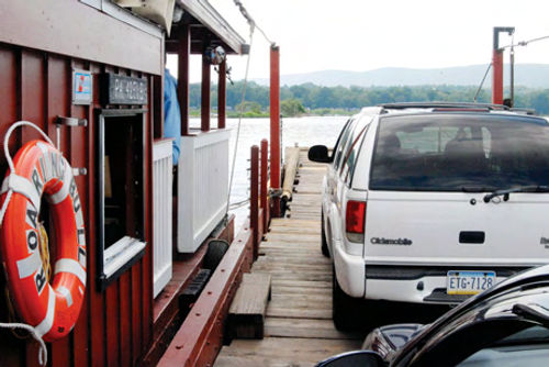 The Roaring Bull V is moving west of Millersburg in the middle of the Susquehanna River with two cars and their passengers. A ferry has crossed here since 1817.