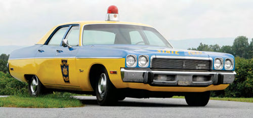 A restored 1973 Plymouth waits in the parking lot of the Pennsylvania State Police Museum.