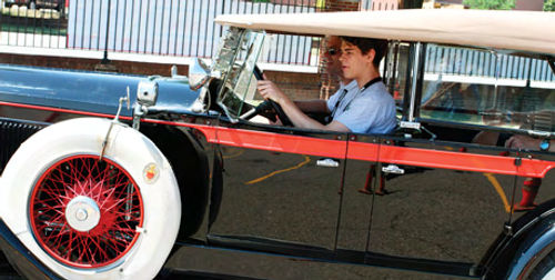This young man looks right at home behind the wheel of a 1928 Packard, doesn’t he?