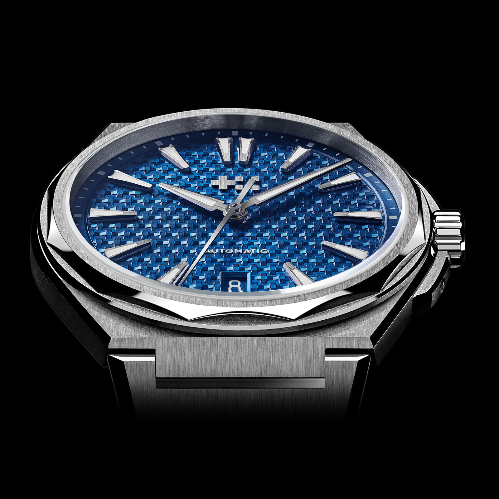 Low front view of the Nordic Blue Twelve 38 on a black background, the light picking out the pyramid texture of the dial and the polished bevel of the bezel