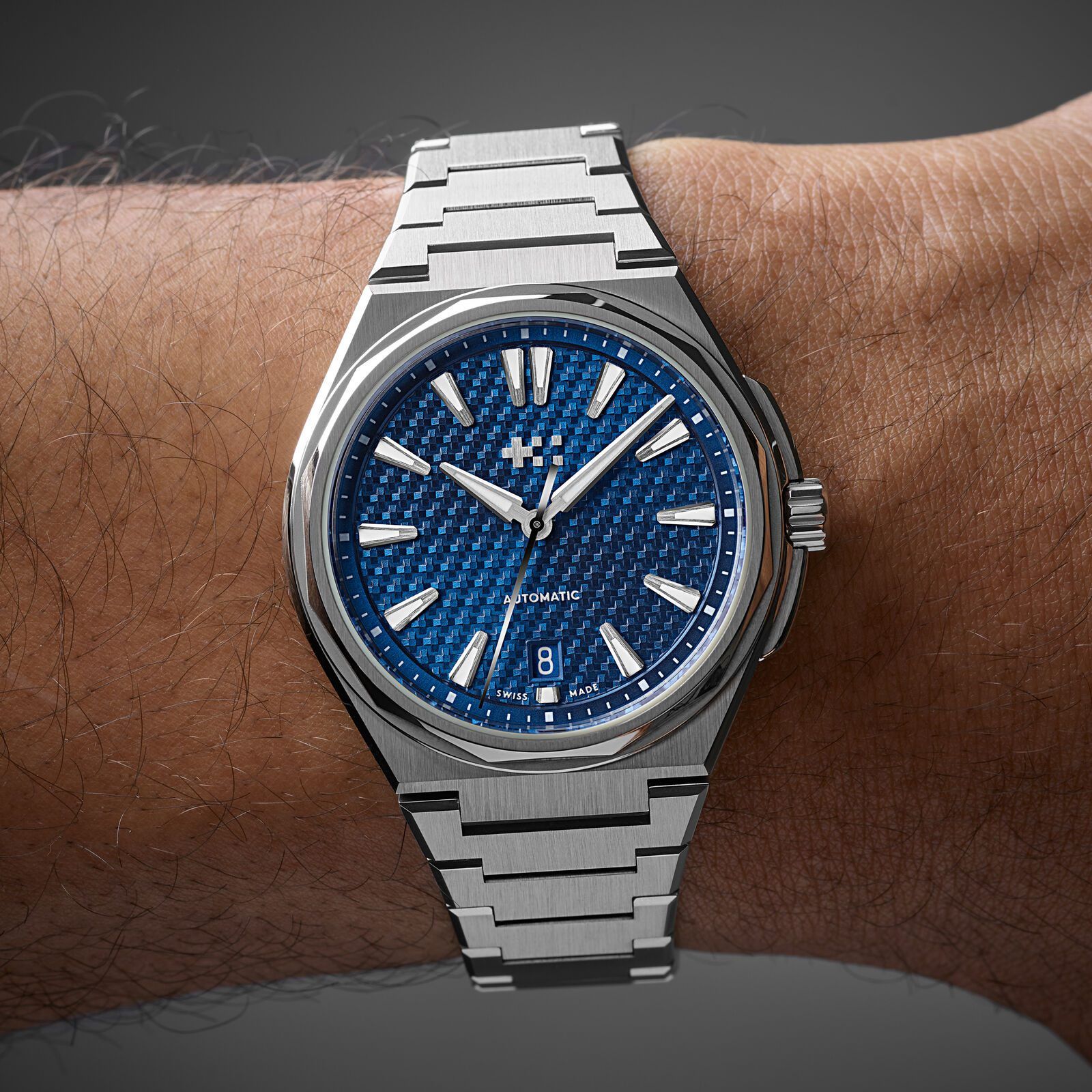 The Nordic Blue Twelve 38 on a man's wrist against a dark background, the bracelet sitting close and the case not overhanging the wrist