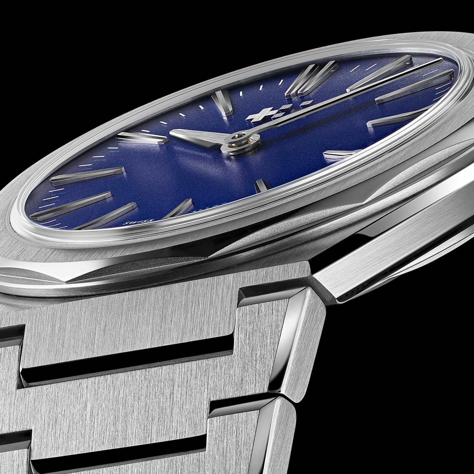 Low-angle close-up of the blue Twelve 660: the thin box sapphire, the grained blue dial with applied indices and the sharp transition from case to the first bracelet link