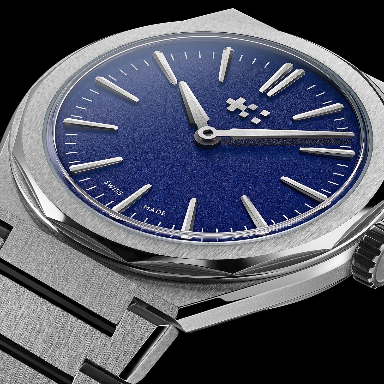 Close-up of the blue Twelve 660 dial: fine grained texture, polished baton indices, the applied twin-flags logo and Swiss Made printed at 6, framed by the brushed and polished 12-sided bezel
