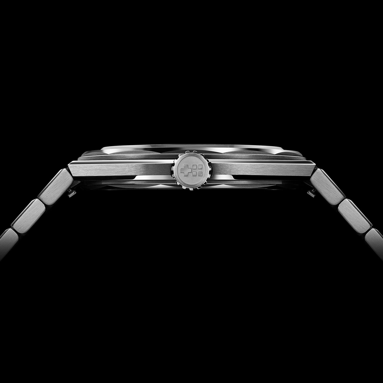 Side view of the Twelve 660 against a black background, showing the very thin case, the slim box sapphire and the flat integrated bracelet links
