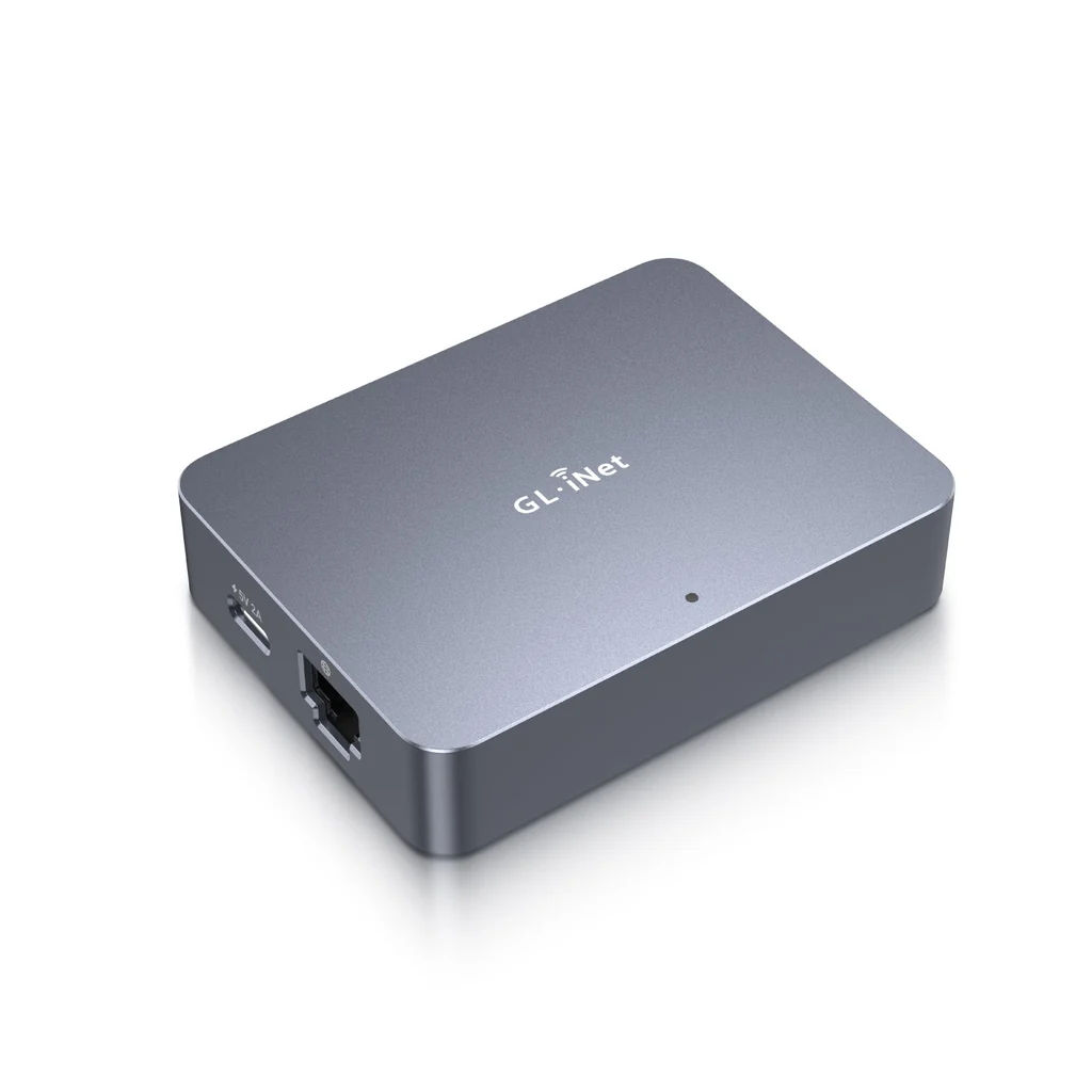 The GL.iNet Comet GL-RM1, a small brushed aluminium box with the GL.iNet logo on top, showing a USB-C power port and a gigabit Ethernet socket on its short side