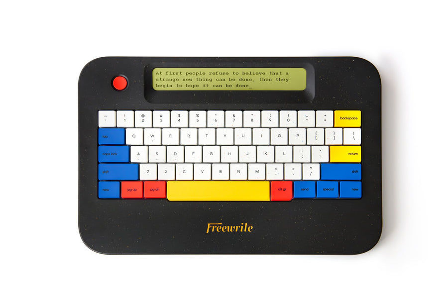 Freewrite Alpha Cosmic Edition, a speckled black terrazzo body with red, blue and yellow keycaps and gold Freewrite lettering