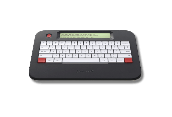Freewrite Alpha in matt black, a wedge-shaped slab with a narrow green LCD strip above white keys and red keys at the bottom corners