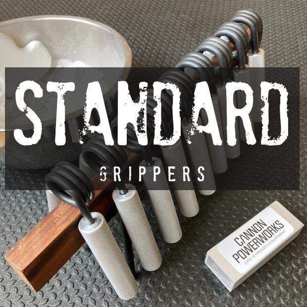 A row of Cannon PowerWorks Standard grippers with white handles, arranged by strength on a diamond-plate surface