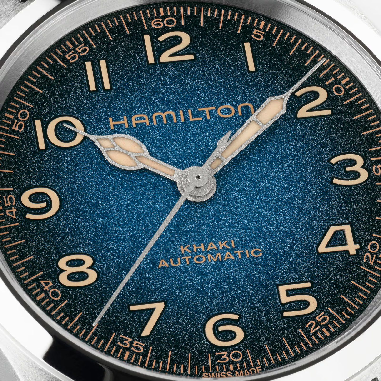Macro of the blue Murph dial showing the grainy stardust finish, domed cream numerals and the nickel-plated cathedral hands