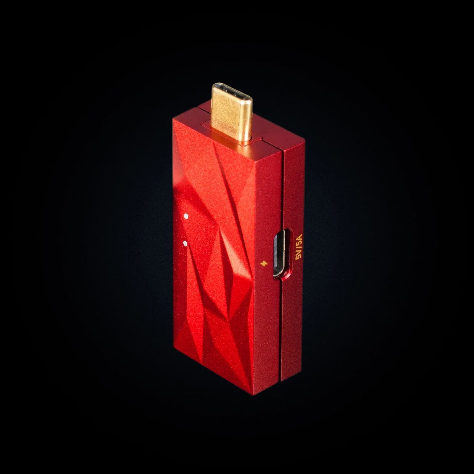 iFi iDefender Max in faceted red aluminium, gold USB-C plug on top and a side USB-C power input marked 5V/5A, on a black background