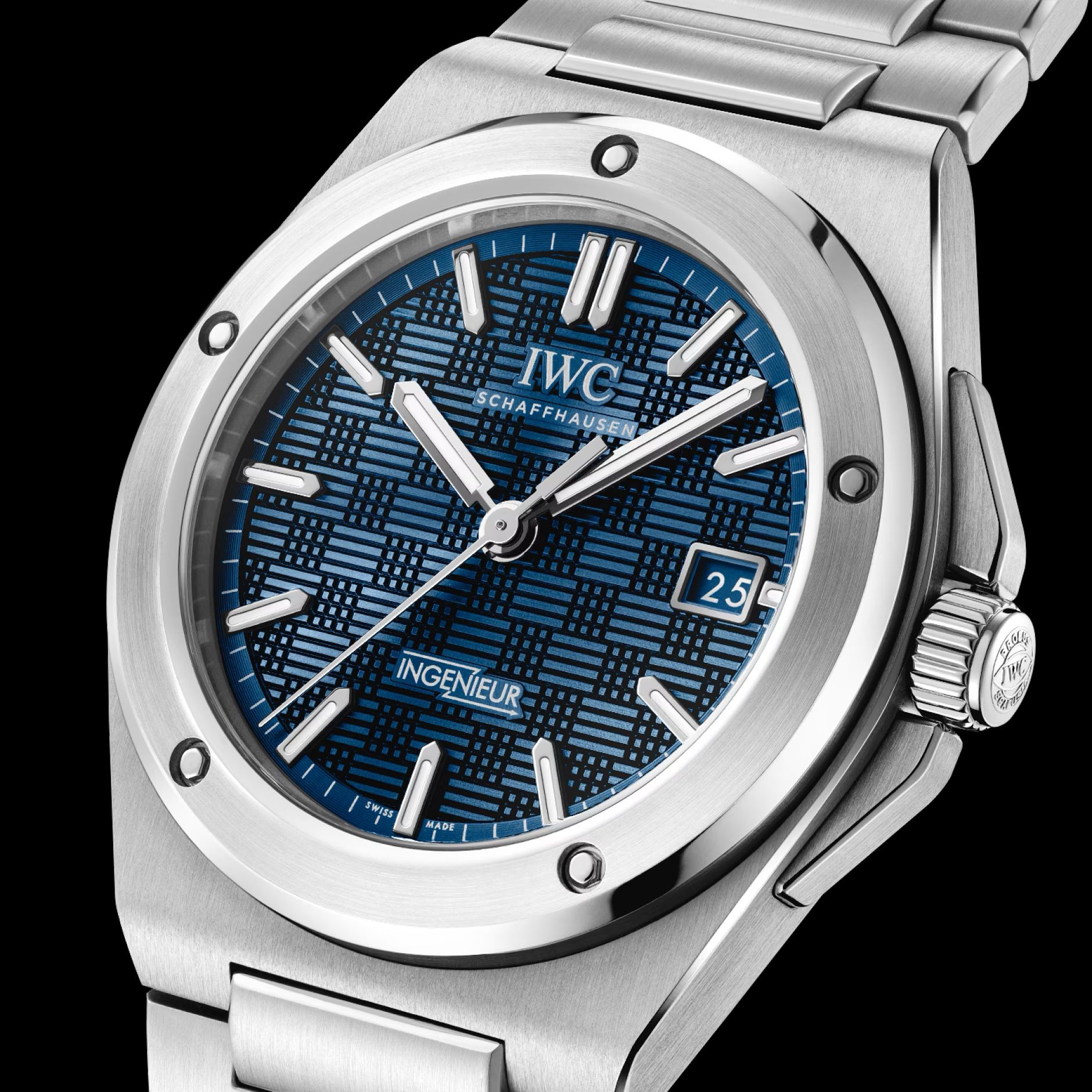Close view of the Ingenieur dial at an angle, the stamped grid pattern catching light across the blue, with the date at three and the fluted crown