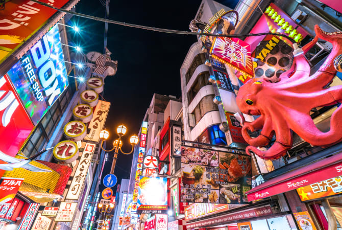 Osaka's Dotonbori at night, packed with neon signs and a giant red octopus sculpture above a takoyaki stand