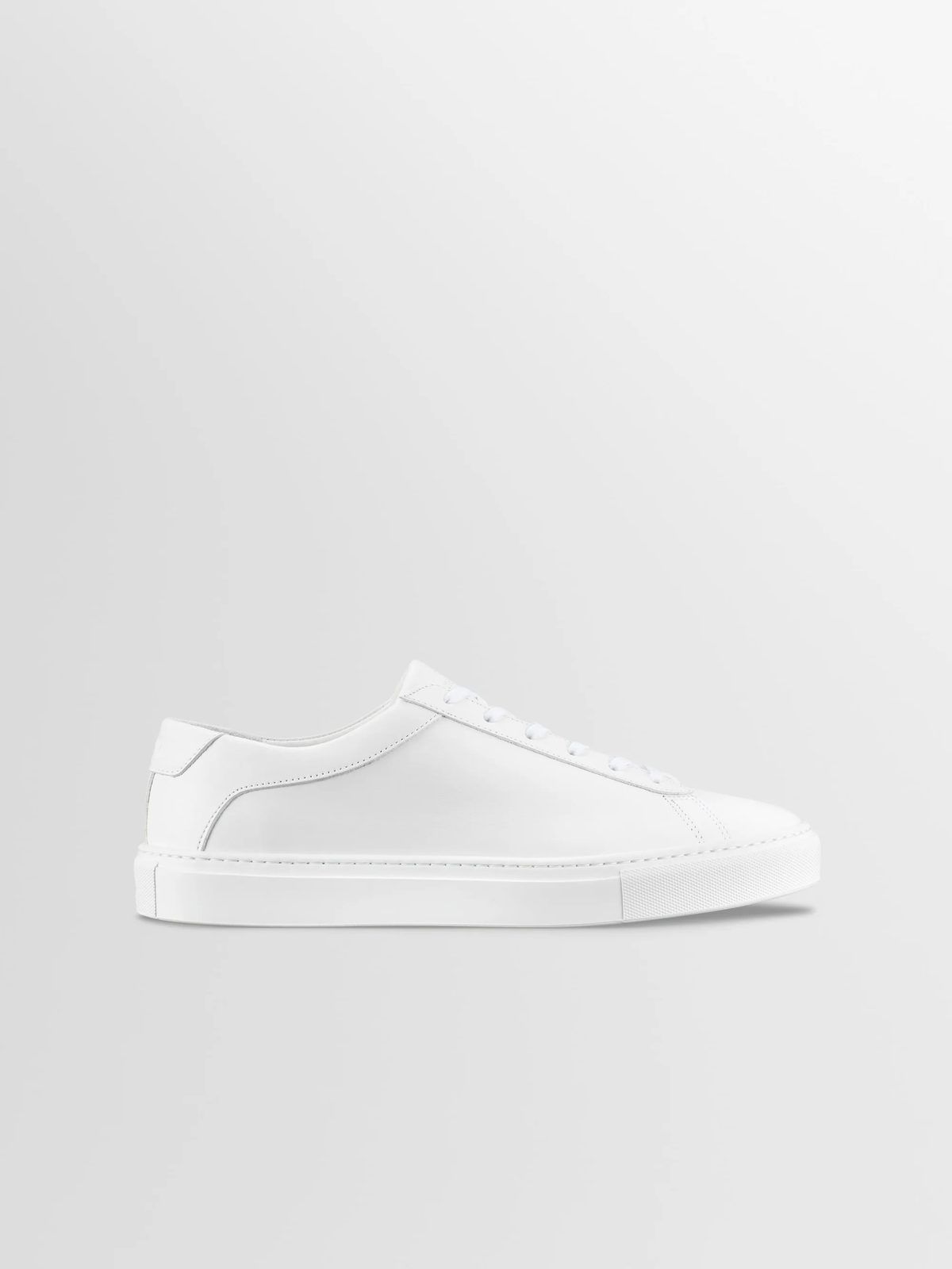 Koio Capri sneaker in triple white, side profile showing the smooth leather upper and white cupsole