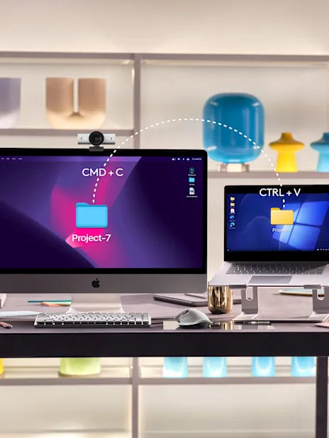 Logitech's illustration of Flow: a folder copied on an iMac with Cmd+C and pasted on a Windows laptop with Ctrl+V