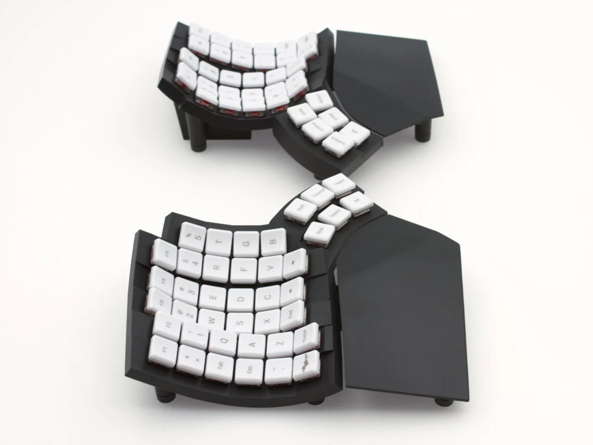 MoErgo GO60 split ergonomic keyboard with white keycaps, curved key wells and separate thumb clusters
