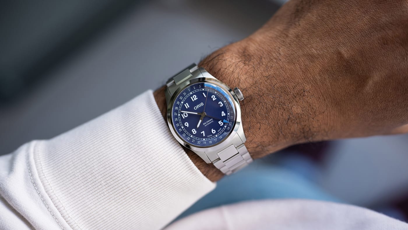 The Big Crown Pointer Date worn under a white sweatshirt cuff, the dial reading blue-violet in daylight against the brushed bracelet